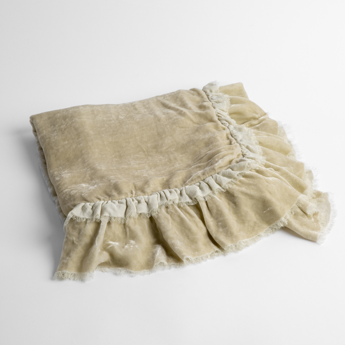Loulah Baby Blanket | Parchment | an overhead shot of a folded silk velvet baby blanket with a raw-edged eyelash ruffle detail.