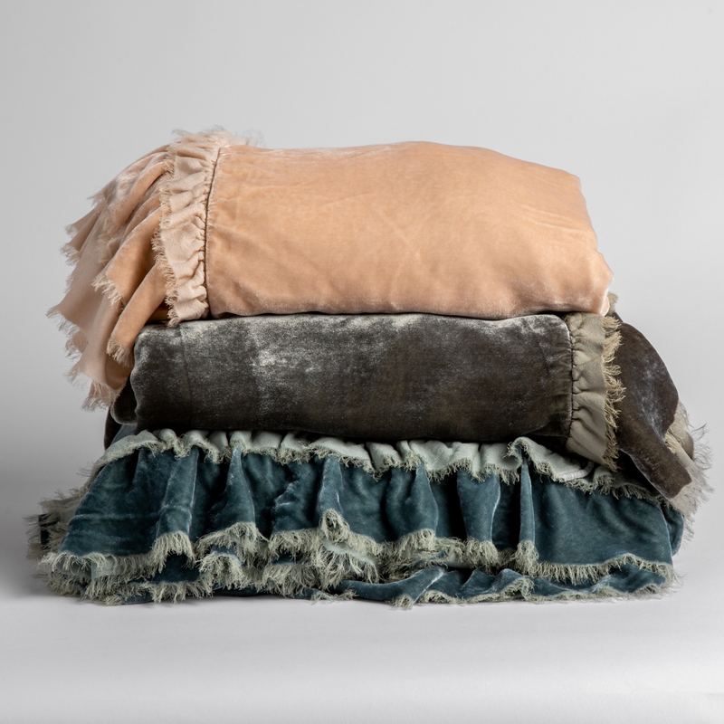 three loulah blankets stacked to show raw-edged eyelash ruffle details. Shown in Pearl, Fog and Mineral against a white background.