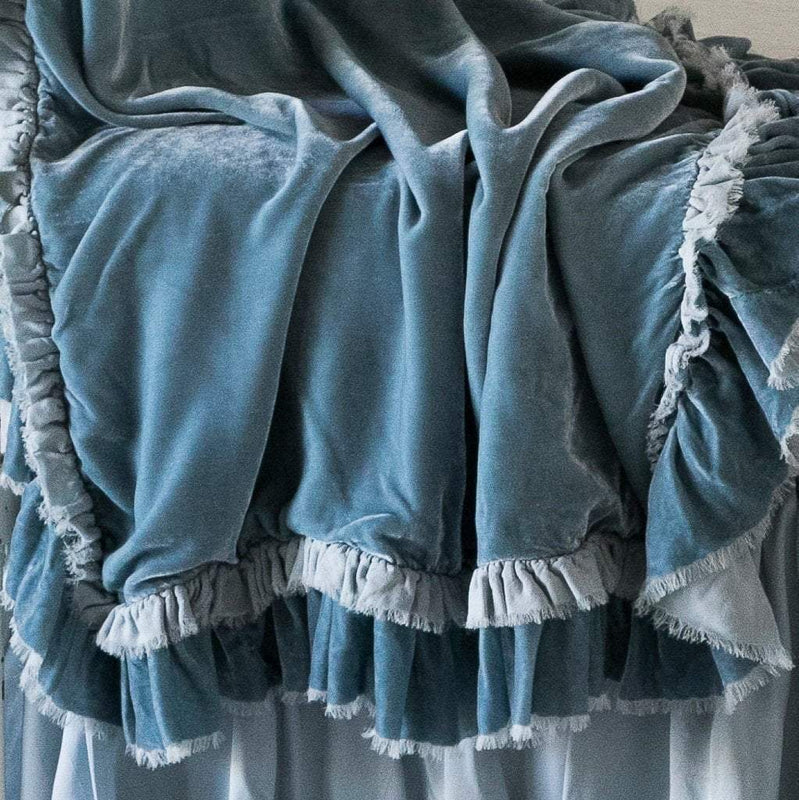 Close-up of rumpled Loulah baby blanket in cloud, showcasing the raw edge ruffle trim.