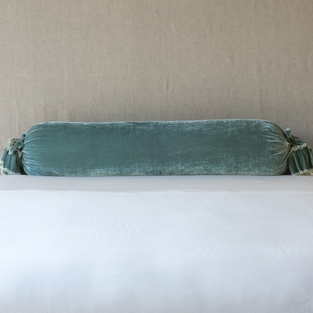 Loulah Throw Pillow | Eucalyptus | bolster shown against neutral background and white foreground