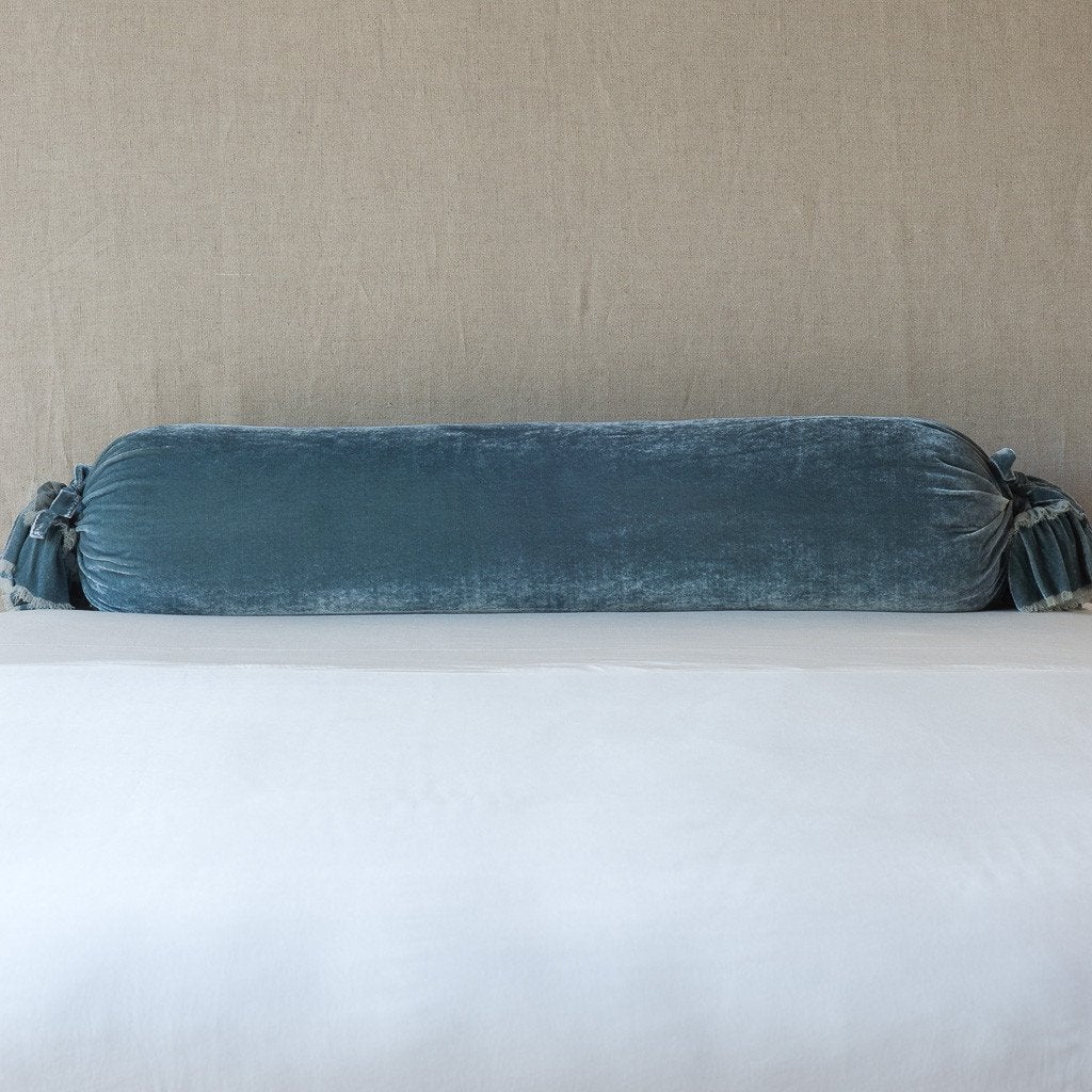 Loulah Throw Pillow | Mineral | bolster shown against neutral background and white foreground