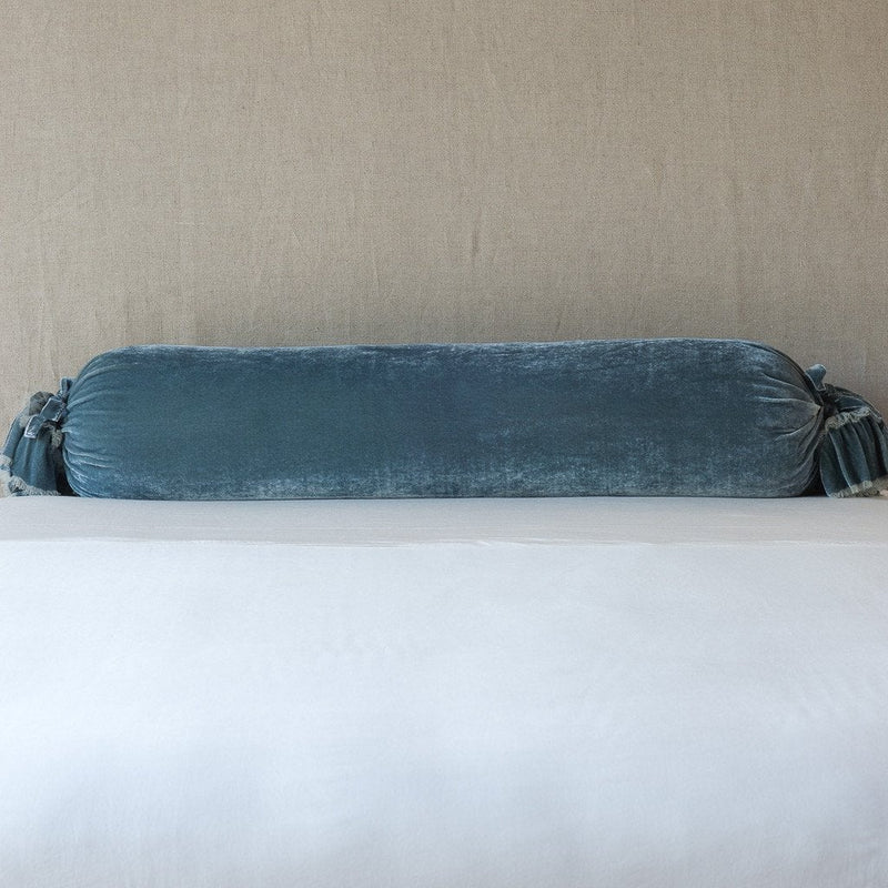 Loulah Throw Pillow | Mineral | bolster shown against neutral background and white foreground