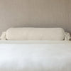 Loulah Throw Pillow | Parchment | bolster shown against neutral background and white foreground