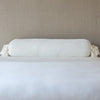 Loulah Throw Pillow | Winter White | bolster shown against neutral background and white foreground