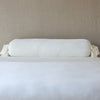 Loulah Throw Pillow | Winter White | bolster shown against neutral background and white foreground