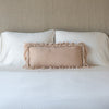 Loulah Throw Pillow | Pearl | pillow on a white bed - cropped end of bed view.