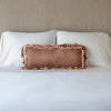 Loulah Throw Pillow | Rouge | pillow on a white bed - cropped end of bed view.