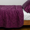 Luna Coverlet | Fig | coverlet with charmeuse pillow on white sheeting - side view.