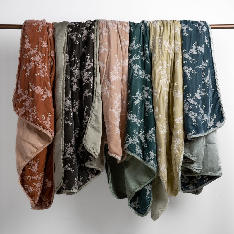 Lynette Blanket | embroidered silk velvet blankets with charmeuse backs and trimsdraped over a copper bar straight on against a white background.