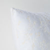 Lynette Throw Pillow | White | Corner detail close-up, highlighting two-tone embroidery and linen back.