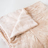 Lynette Blanket | Pearl | Lynette throw blanket in pearl, neatly folded on a light background, with a corner turned back to  showcase the linen back - slight overhead angle.