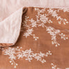 Lynette Blanket | Rouge | Close up of blanket, with a corner turned back to showcase the linen back - overhead view.