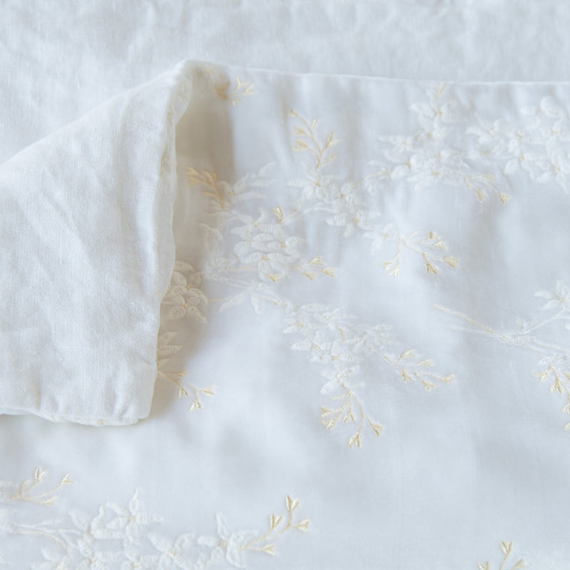 Lynette Blanket | White | Close up of blanket, with a corner turned back to showcase the linen back - overhead view.