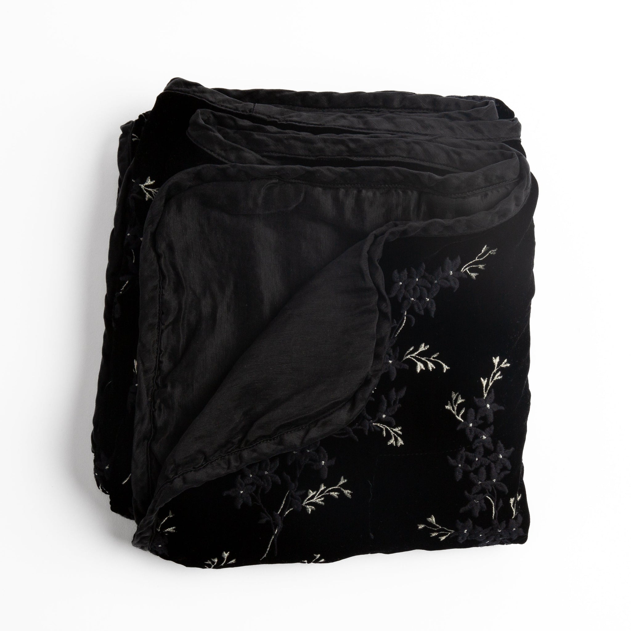 Lynette Blanket | Corvino | overhead angle of the folded blanket with a corner pulled back to show the reverse and trim.