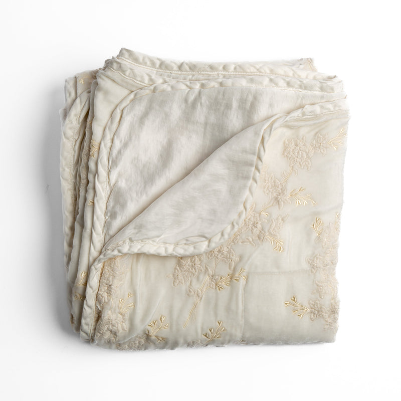 Lynette Blanket | Winter White | overhead angle of the folded blanket with a corner pulled back to show the reverse and trim.