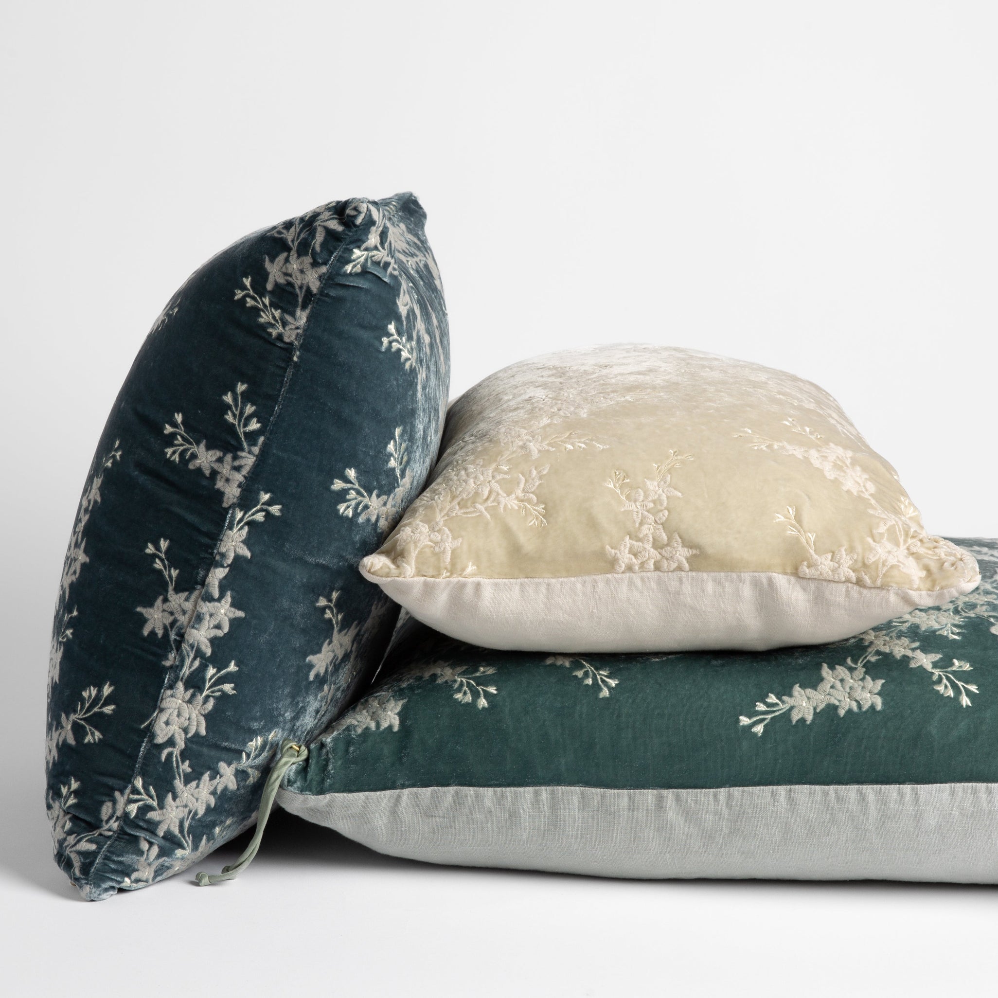embroidered silk velvet throw pillows stacked to show both sides of all pillow styles — straight on against a white background. 