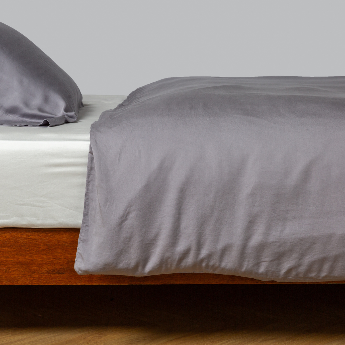Madera Luxe Duvet Cover | French Lavender | tencel™ duvet cover with matching pillowcase from the madera luxe collection on a bed with a winter white fitted sheet - side view.
