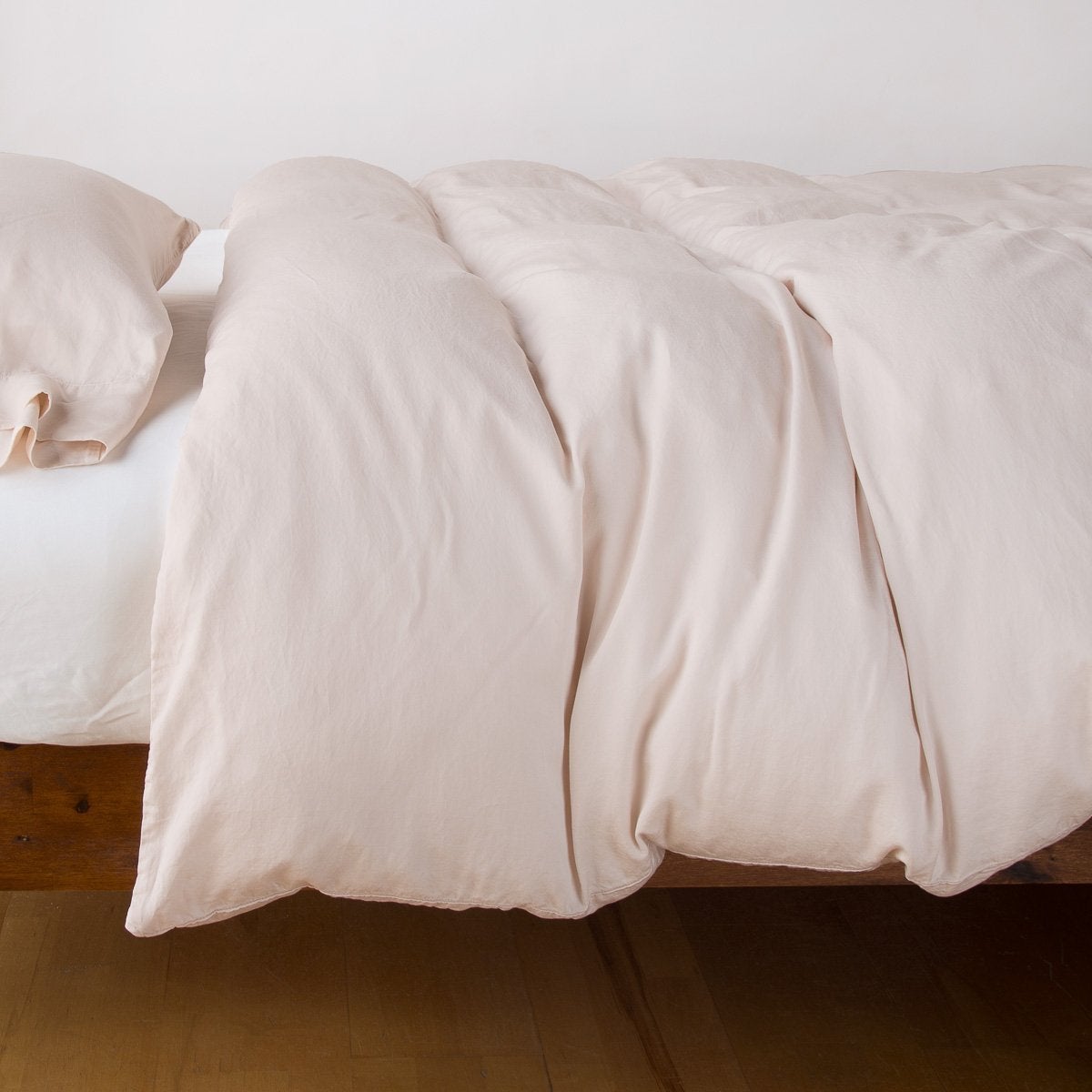 Pearl | Madera Luxe duvet cover with matching sleeping pillow and white fitted sheet - pearl, side view.