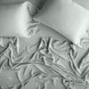 Madera Luxe Fitted Sheet | Eucalyptus | rumpled sheeting and sleeping pillows - overhead view.