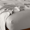 Madera Luxe Twin Fitted Sheets | Fog | fitted sheet with matching rumpled flat sheet - top corner view.