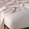 Madera Luxe Twin Fitted Sheets | Madera Luxe fitted sheet in pearl with matching rumpled flat sheet - shown from top corner.