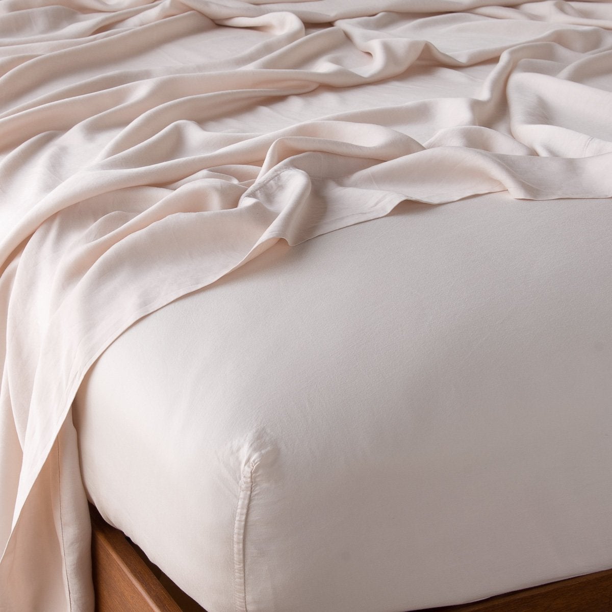 Madera Luxe Twin Fitted Sheets | Pearl | Madera Luxe fitted sheet in pearl with matching rumpled flat sheet - shown from top corner.