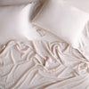 Madera Luxe Fitted Sheet | Pearl | rumpled sheeting and sleeping pillows - overhead view.