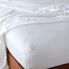 Madera Luxe Twin Fitted Sheets | White | fitted sheet with matching rumpled flat sheet - top corner view.