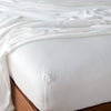 Madera Luxe Twin Fitted Sheets | Winter White | fitted sheet with matching rumpled flat sheet - top corner view.