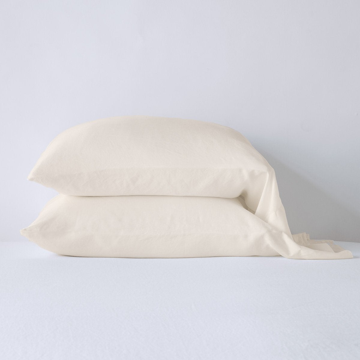 Madera Luxe Standard Pillowcase (Single) | Parchment | sleeping pillows stacked neatly against a white backdrop - side view.