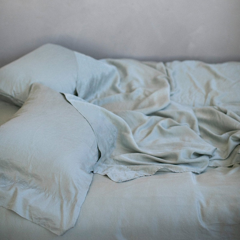 Madera Luxe Pillowcase (Single) | Mineral | Rumpled Madera Luxe sleeping pillows and matching sheeting - mineral, slightly overhead side view.