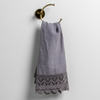 Mattine Guest Towel | French Lavender | linen with mattine lace trimmed guest towel on a decorative towel ring mounted on a white wall.