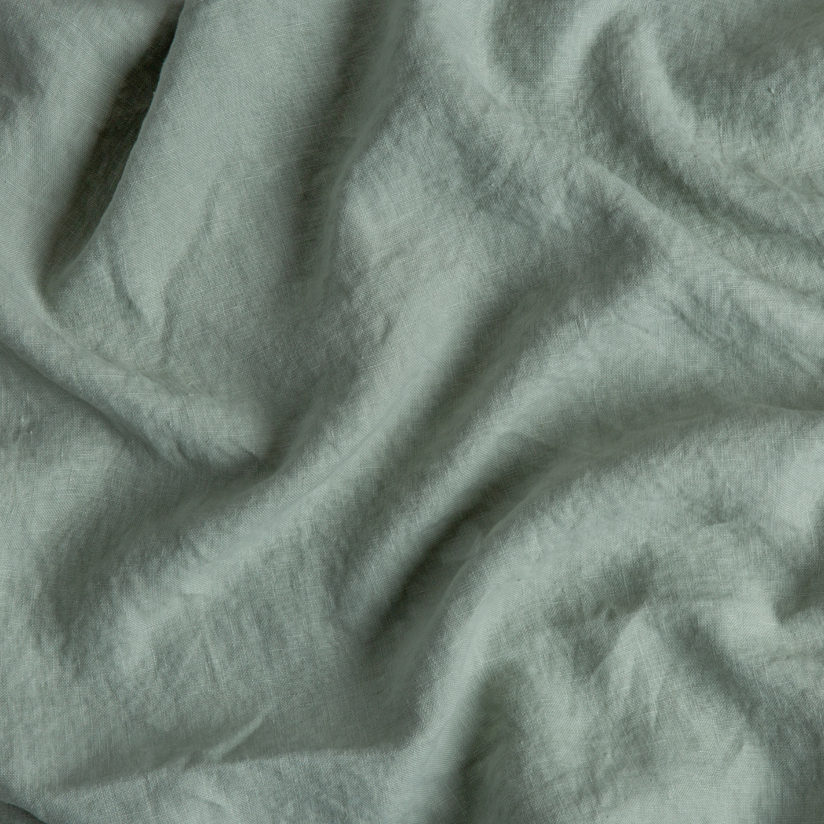 Midweight Linen Swatch Card | Eucalyptus | A close up of midweight linen fabric in eucalyptus, a soft light green.