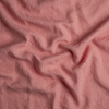 Austin Throw Pillow | Poppy | A close up of midweight linen fabric in poppy, a warm coral pink.
