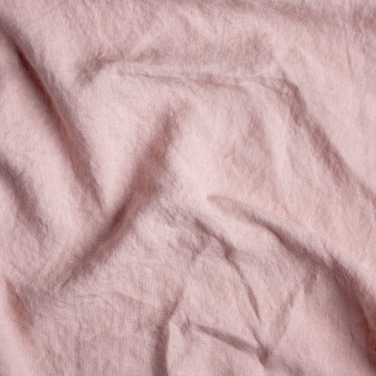 Austin Bed Skirt | Rouge | A close up of midweight linen fabric in rouge, a mid-tone blush pink.