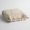 Mirabella Baby Blanket — Limited Release | Pearl | a silk and tencel™ jacquard baby blanket folded and shot against a white background with the ruffled trim situated to be visible