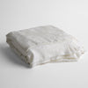 Mirabella Baby Blanket — Limited Release | White | a silk and tencel™ jacquard baby blanket folded and shot against a white background with the ruffled trim situated to be visible