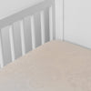 Mirabella Crib Sheet — Limited Release | Pearl | a silk and tencel™ crib sheet shown slightly overhread and shot into the corner of a white crib.