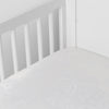 Mirabella Crib Sheet — Limited Release | White | a silk and tencel™ crib sheet shown slightly overhread and shot into the corner of a white crib.
