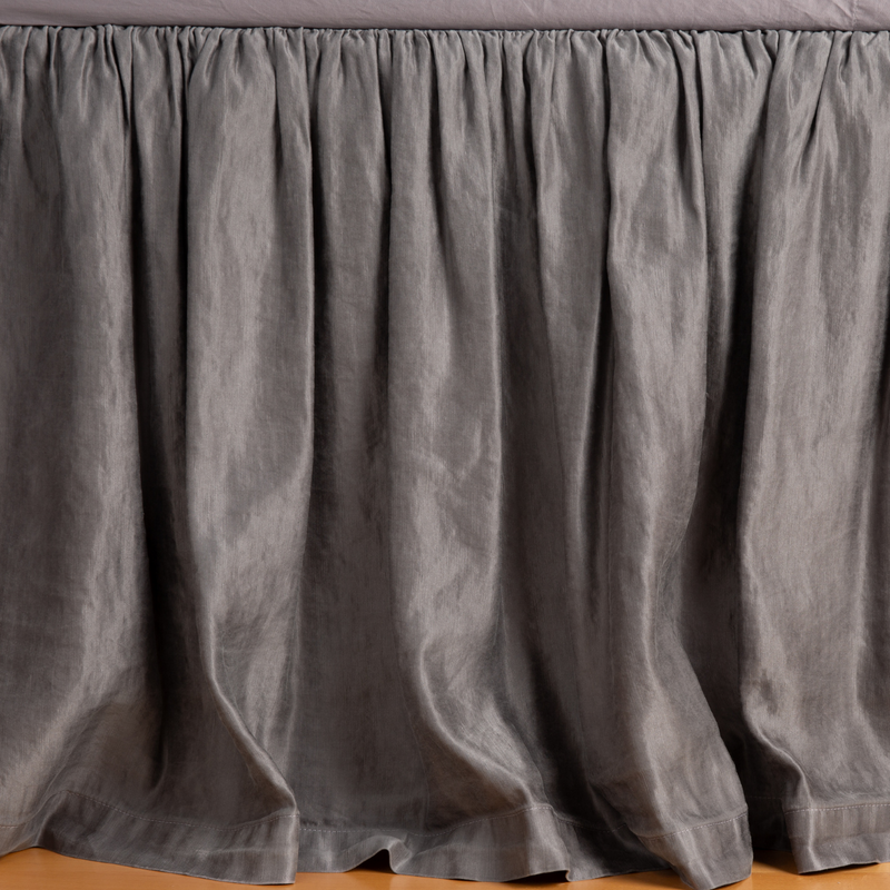 Paloma Bed Skirt | French Lavender | charmeuse bed skirt panel with matching fitted sheet — shot with the focus on the skirt gently pooling on the floor.