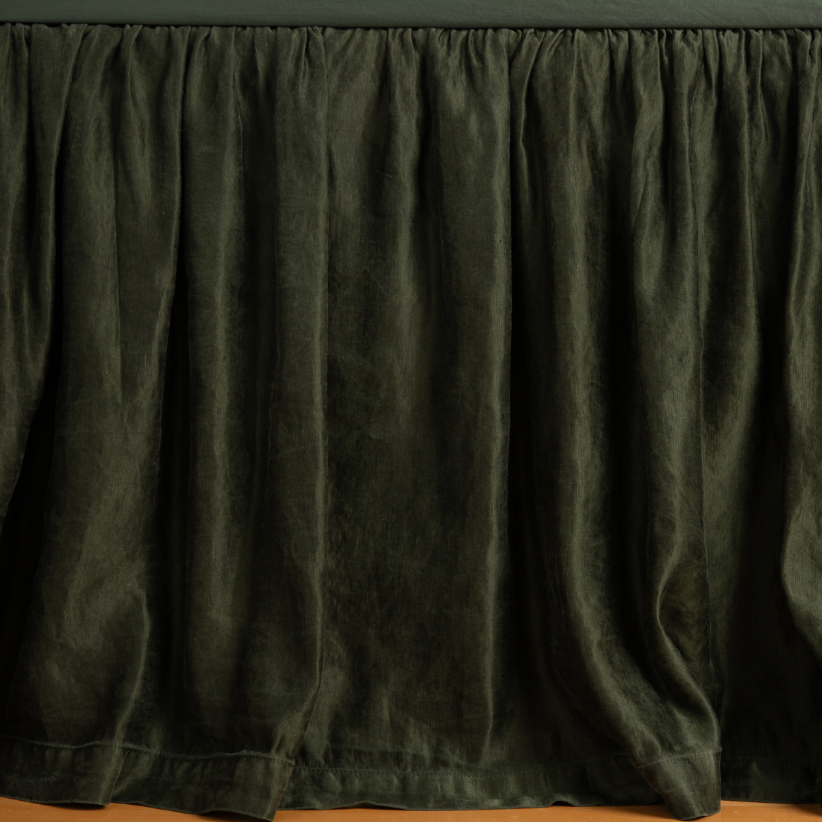 Paloma Bed Skirt | Juniper | charmeuse bed skirt panel with matching fitted sheet - shot with an emphasis on the skirt with its edge barely dusting the floor.