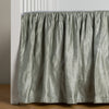 Paloma Crib Skirt | Mineral | charmeuse crib skirt shown on a white crib against a white wall and medium wood floor.