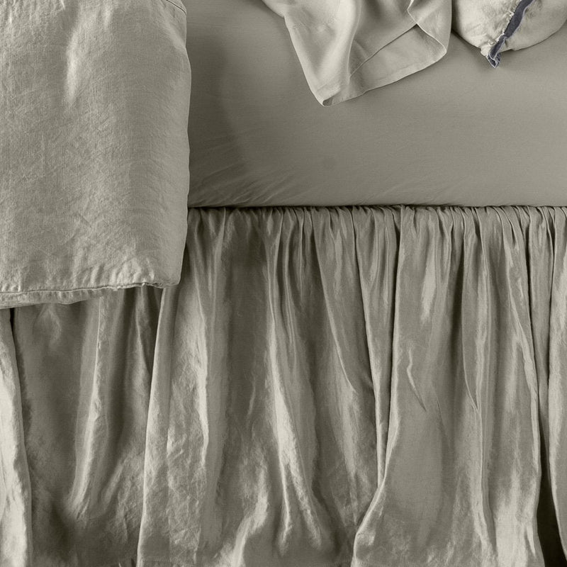 Close up of Paloma bed skirt, highlighting the shimmering fabric and the gathering detail - fog, side view.