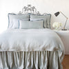 Mineral | Paloma bed skirt with matching duvet, and pillows - mineral, end of bed view.