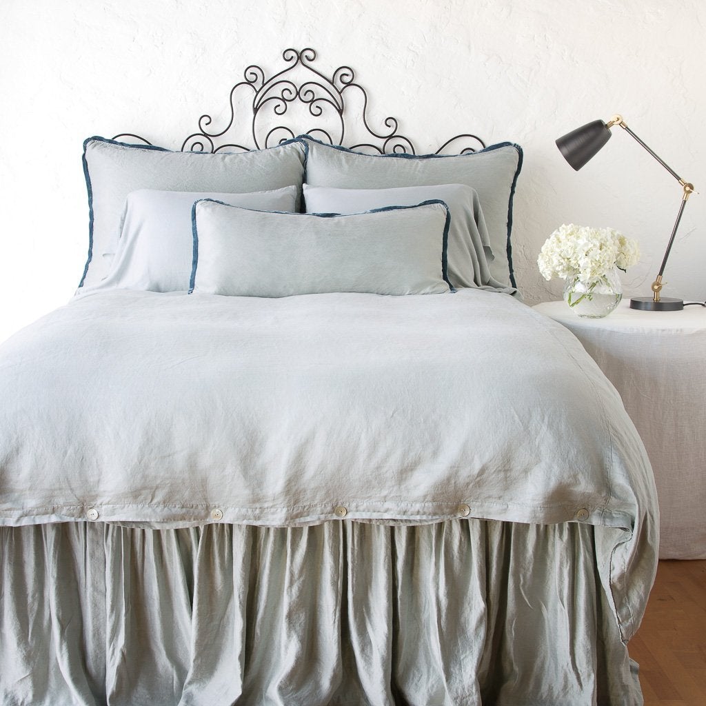Mineral | Paloma bed skirt with matching duvet, and pillows - mineral, end of bed view.