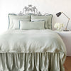 Paloma duvet cover with matching pillows and bed skirt - eucalyptus, end of bed view.