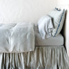 Paloma duvet cover with matching pillows and bed skirt - mineral, side view.