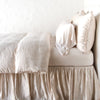 Paloma duvet cover with matching pillows and bed skirt - pearl, side view.