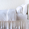 Paloma Duvet Cover | White | duvet cover with matching pillows and bed skirt - side view.
