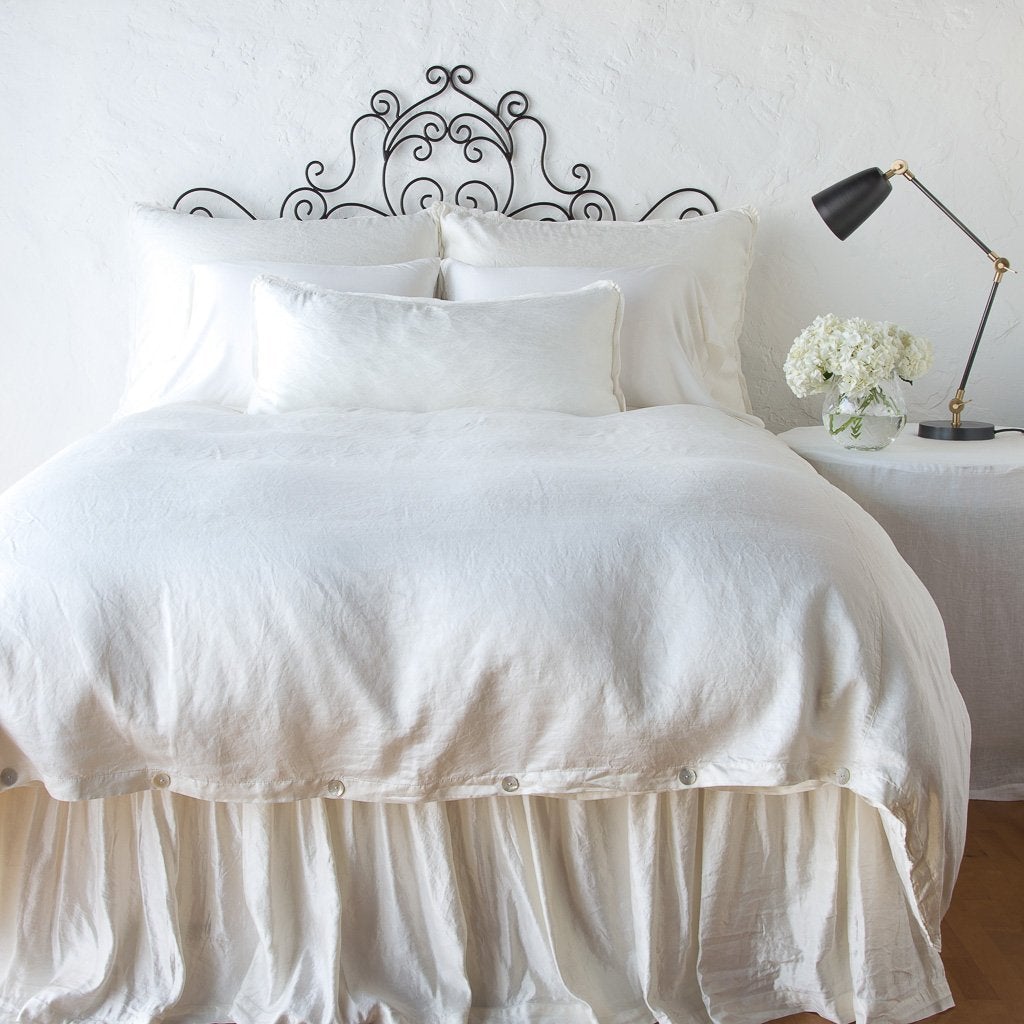 Paloma duvet cover with matching pillows and bed skirt - winter white, end of bed view.